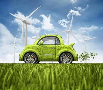 Image of green car in grassy field with windmills