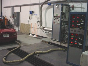 Photo: Hose connected to vehicle tailpipe; sending emissions to test equipment
