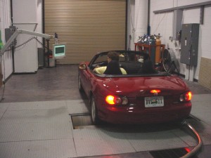 Photo: Driver running car through test cycle on dynamometer